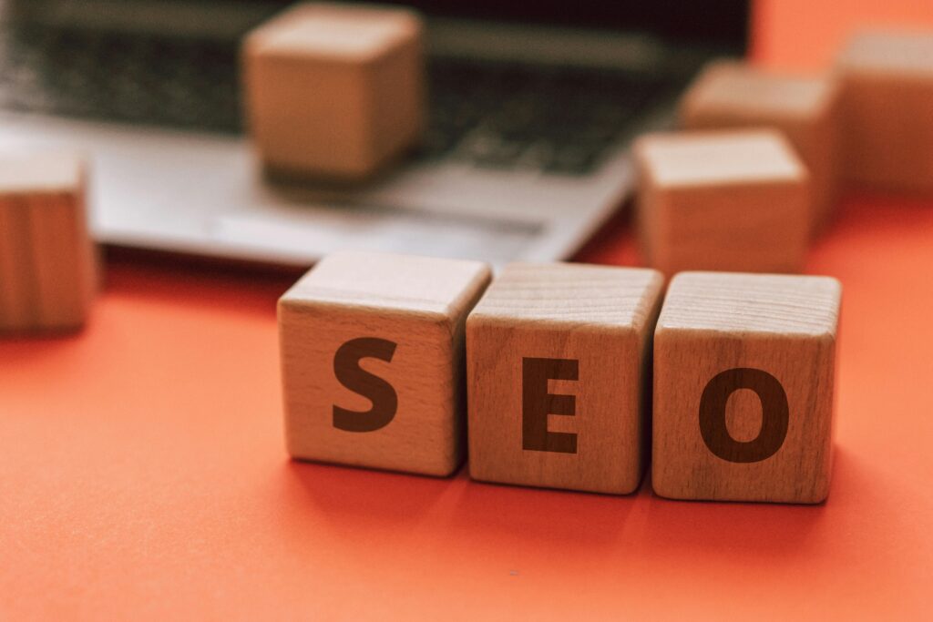 Wooden blocks spelling SEO on a laptop keyboard convey digital marketing concepts.